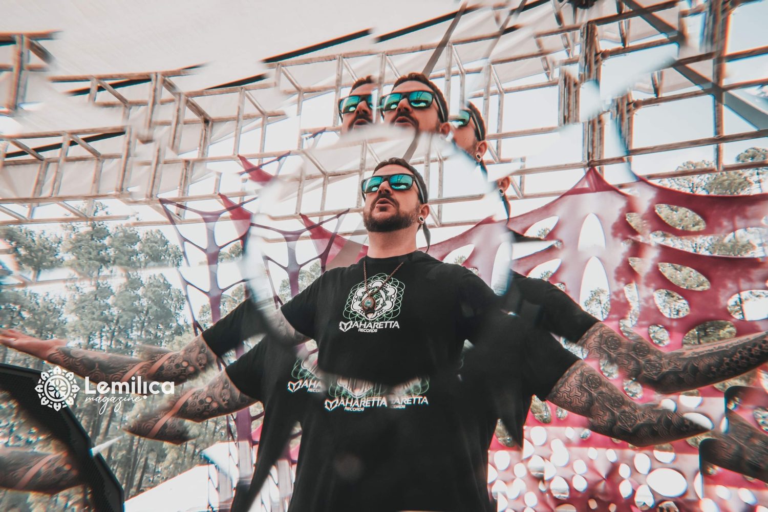 Amplify with arms open under a festival canopy